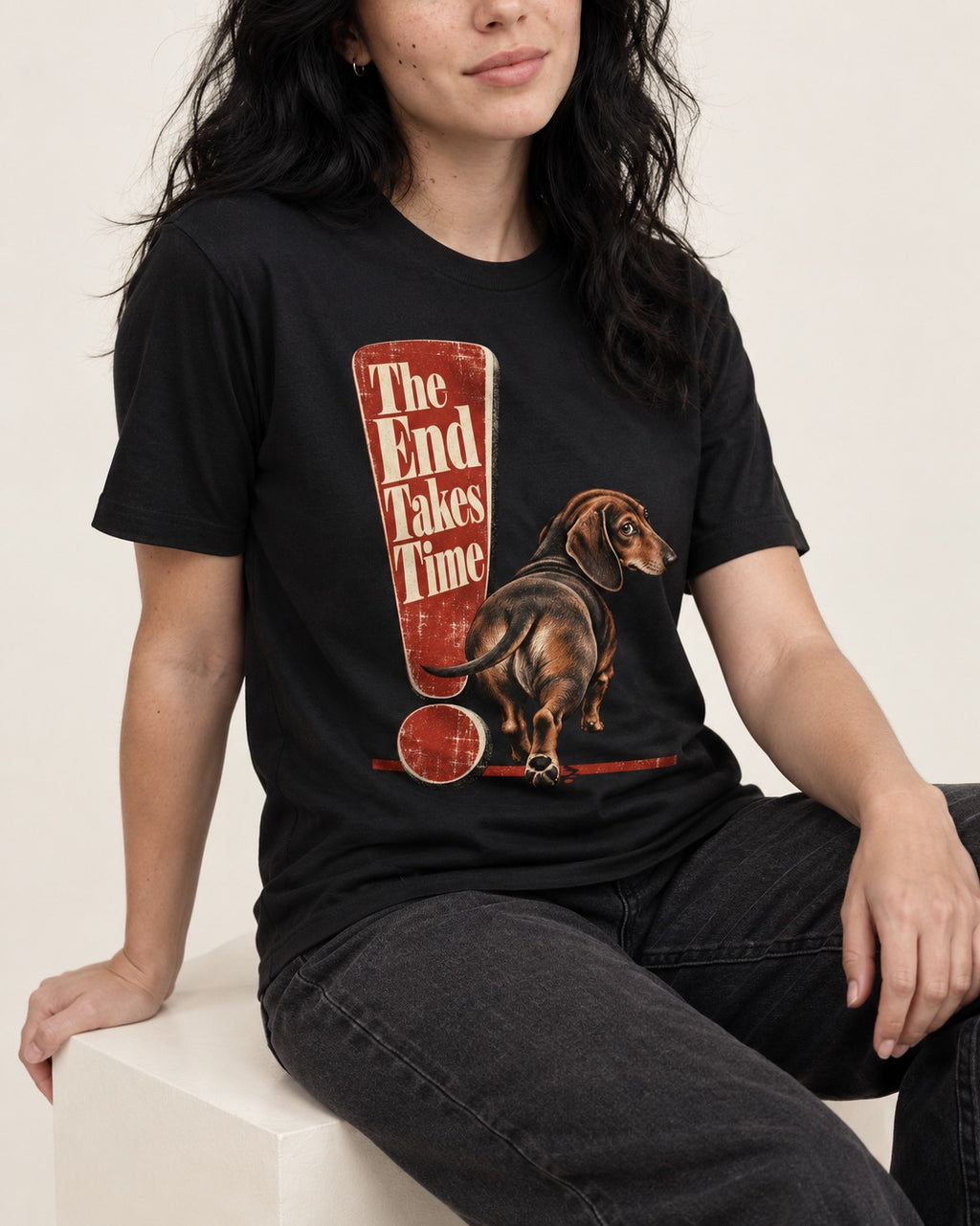 Dachshund The End Takes Time Exclamation Mark Graphic T-Shirt in Black, worn by a seated model