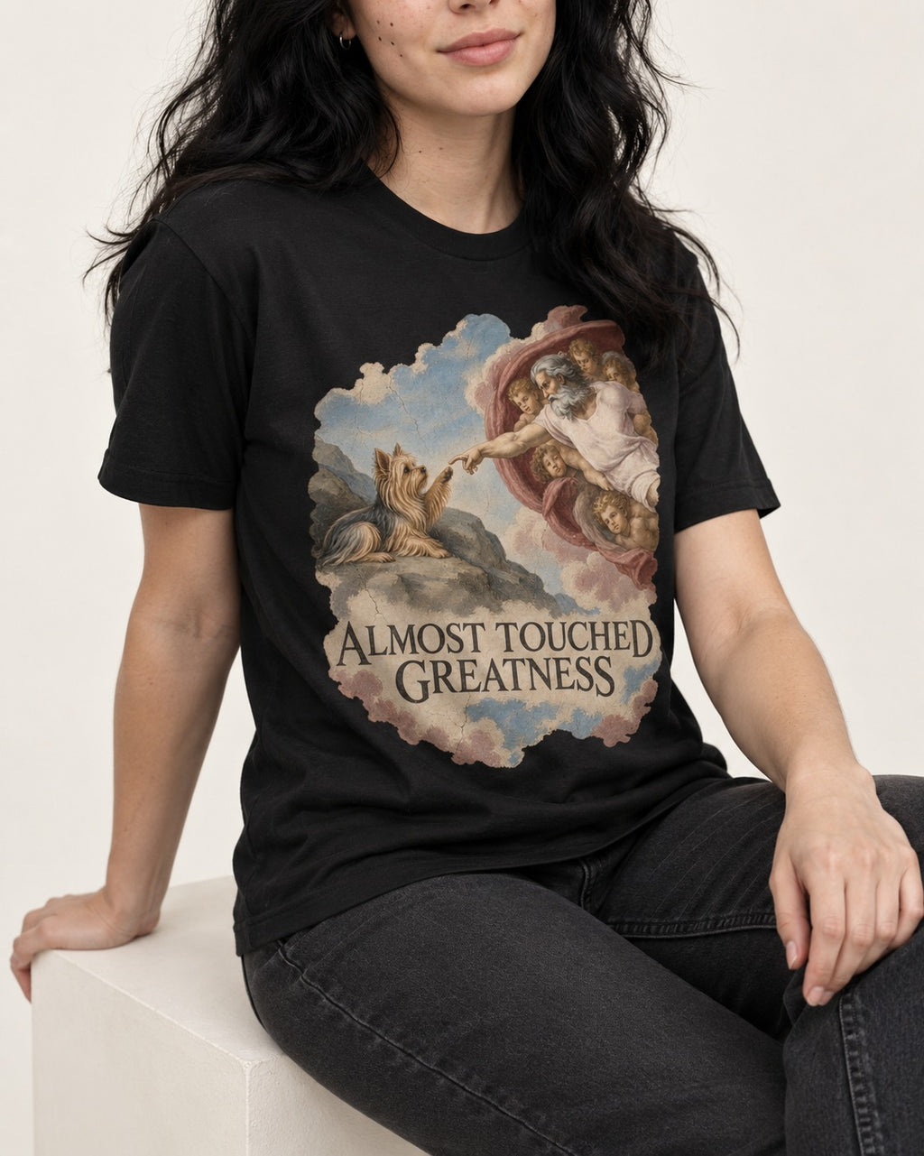 Yorkshire Terrier Almost Touched Greatness Creation Parody Graphic T-Shirt in Black, worn by a seated model