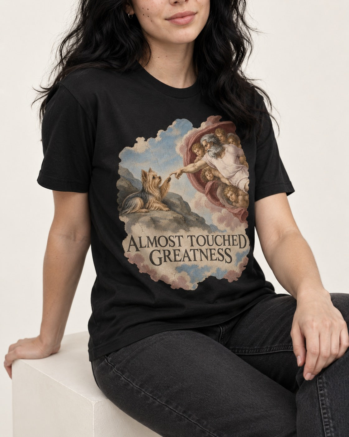 Yorkshire Terrier Almost Touched Greatness Creation Parody Graphic T-Shirt in Black, worn by a seated model