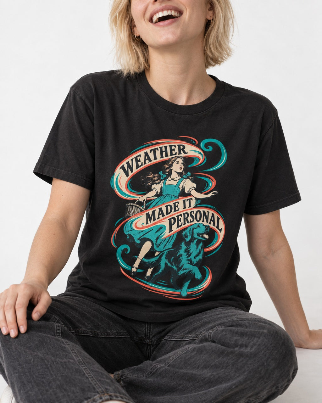 Golden Retriever Weather Made It Personal Woman Graphic T-Shirt in Black, worn by a seated model