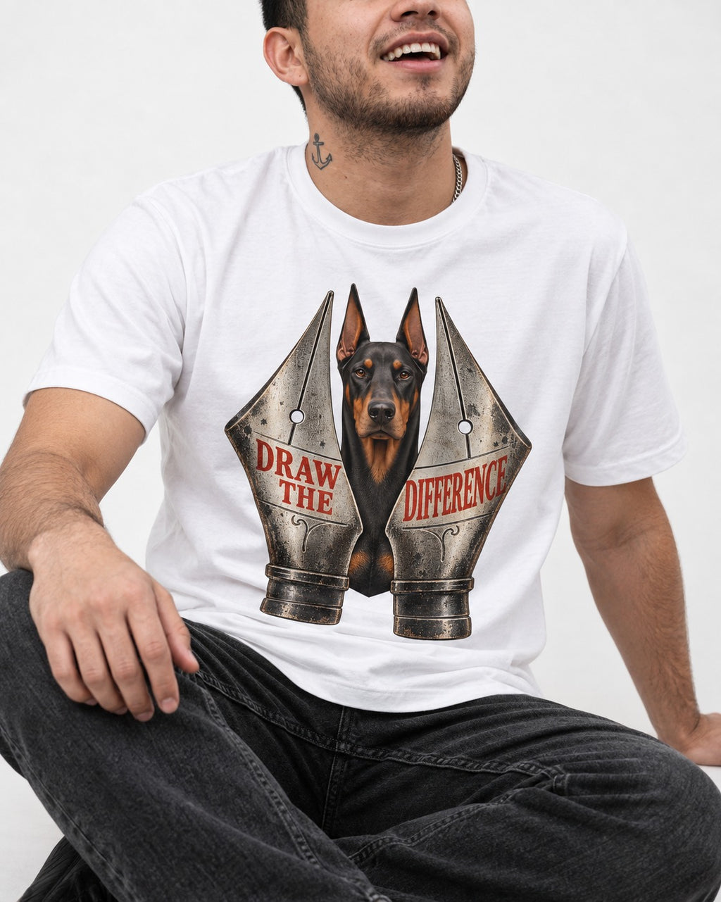 Doberman Draw the Difference T-Shirt in White, worn by a seated model