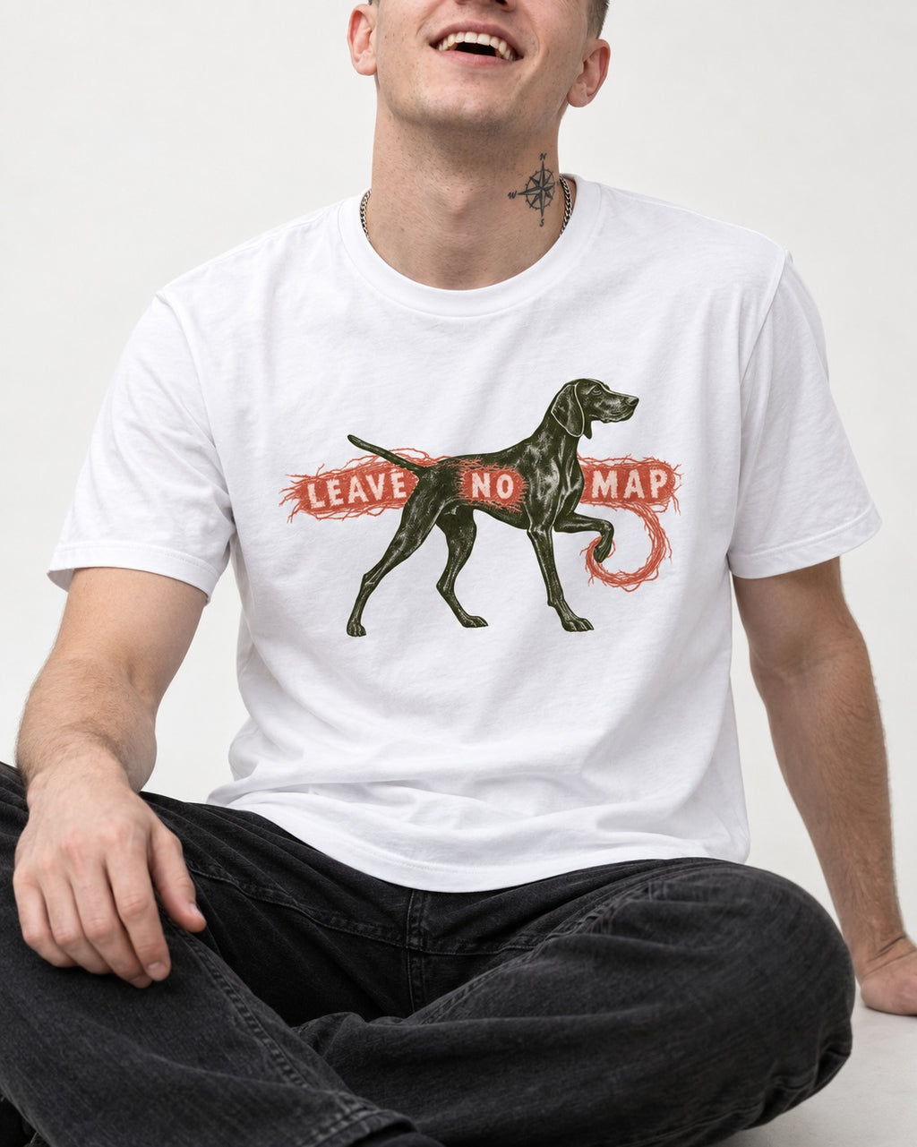Leave No Map German Shorthaired Pointer T-Shirt in White, worn by a seated model