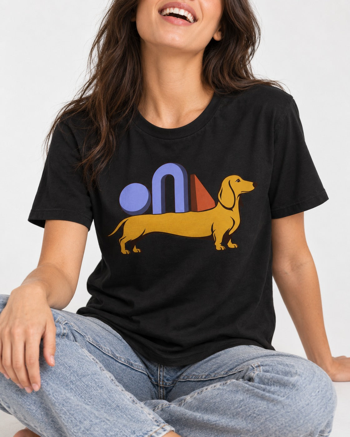 Dachshund Daydream T-Shirt in Black, worn by a seated model