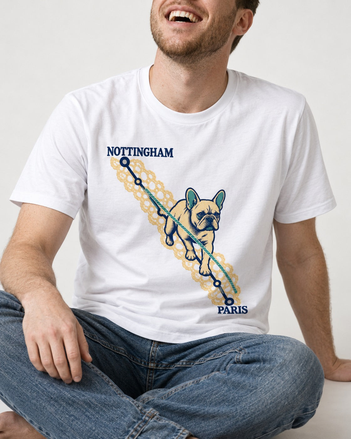Nottingham to Paris Frenchie T-Shirt in White, worn by a seated model