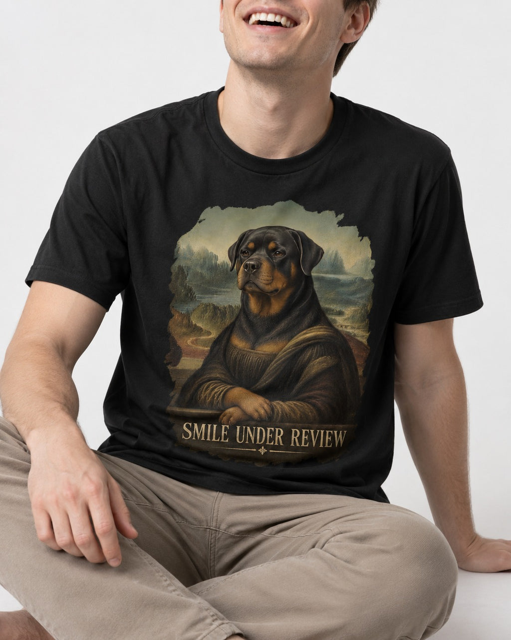 Rottweiler Smile Under Review Renaissance Portrait Graphic T-Shirt in Black, worn by a seated model