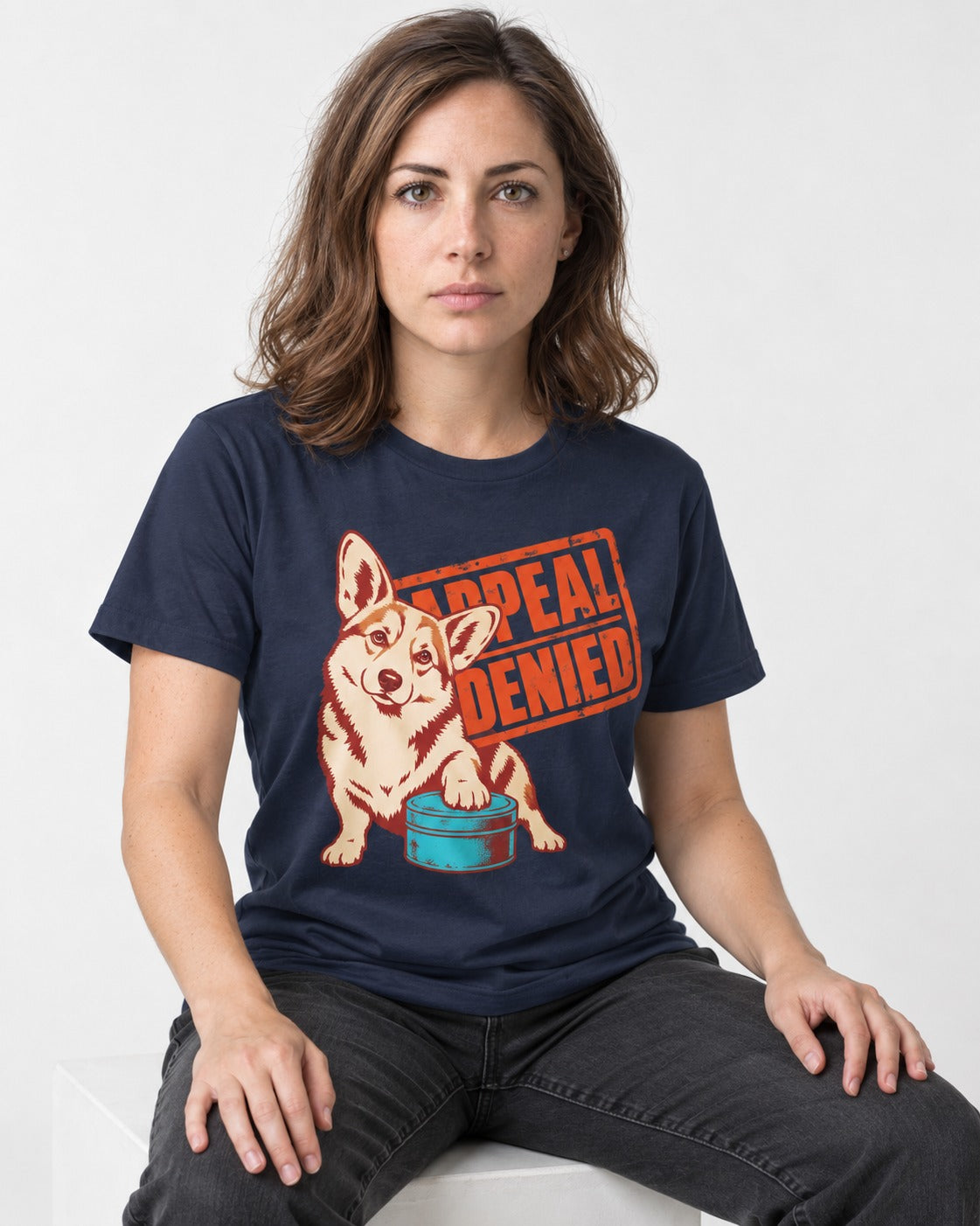 Corgi Appeal Denied Treat Tin T-Shirt in Navy, worn by a seated model