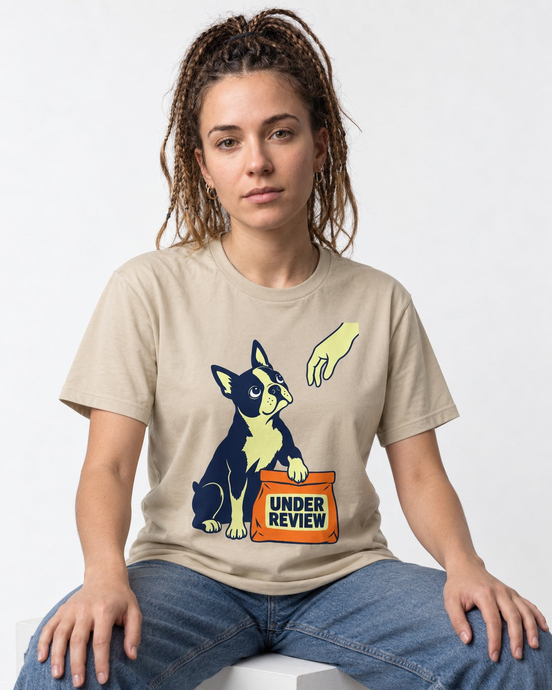 Boston Terrier Under Review T-Shirt in Sand, worn by a seated model