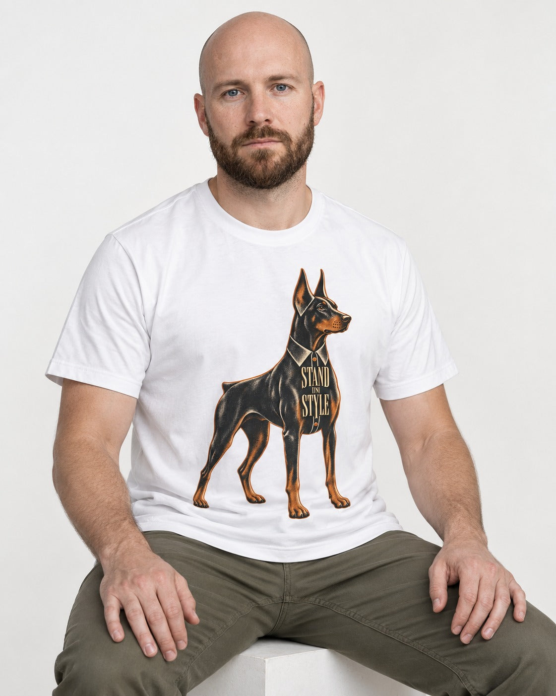 Doberman Stand in Style Suit Graphic T-Shirt in White, worn by a seated model