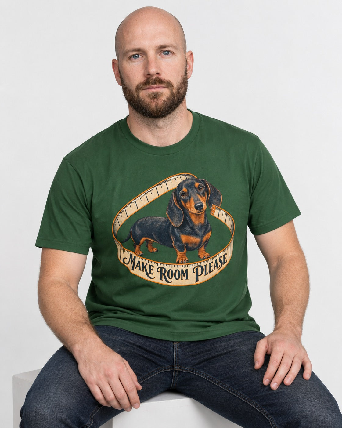 Dachshund Make Room Please Measuring Tape Graphic T-Shirt in Forest Green, worn by a seated model
