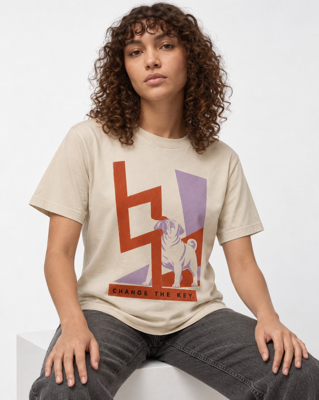 Pug Change the Key T-Shirt in Sand, worn by a seated model