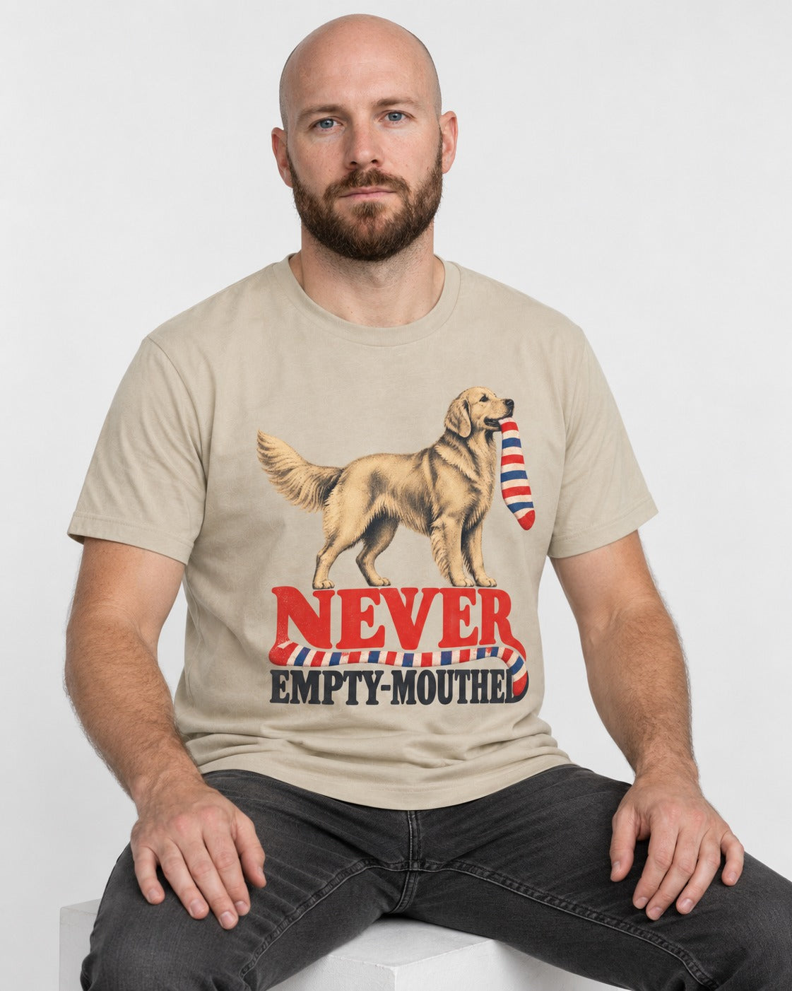 Never Empty Mouthed Golden Retriever T-Shirt in Sand, worn by a seated model