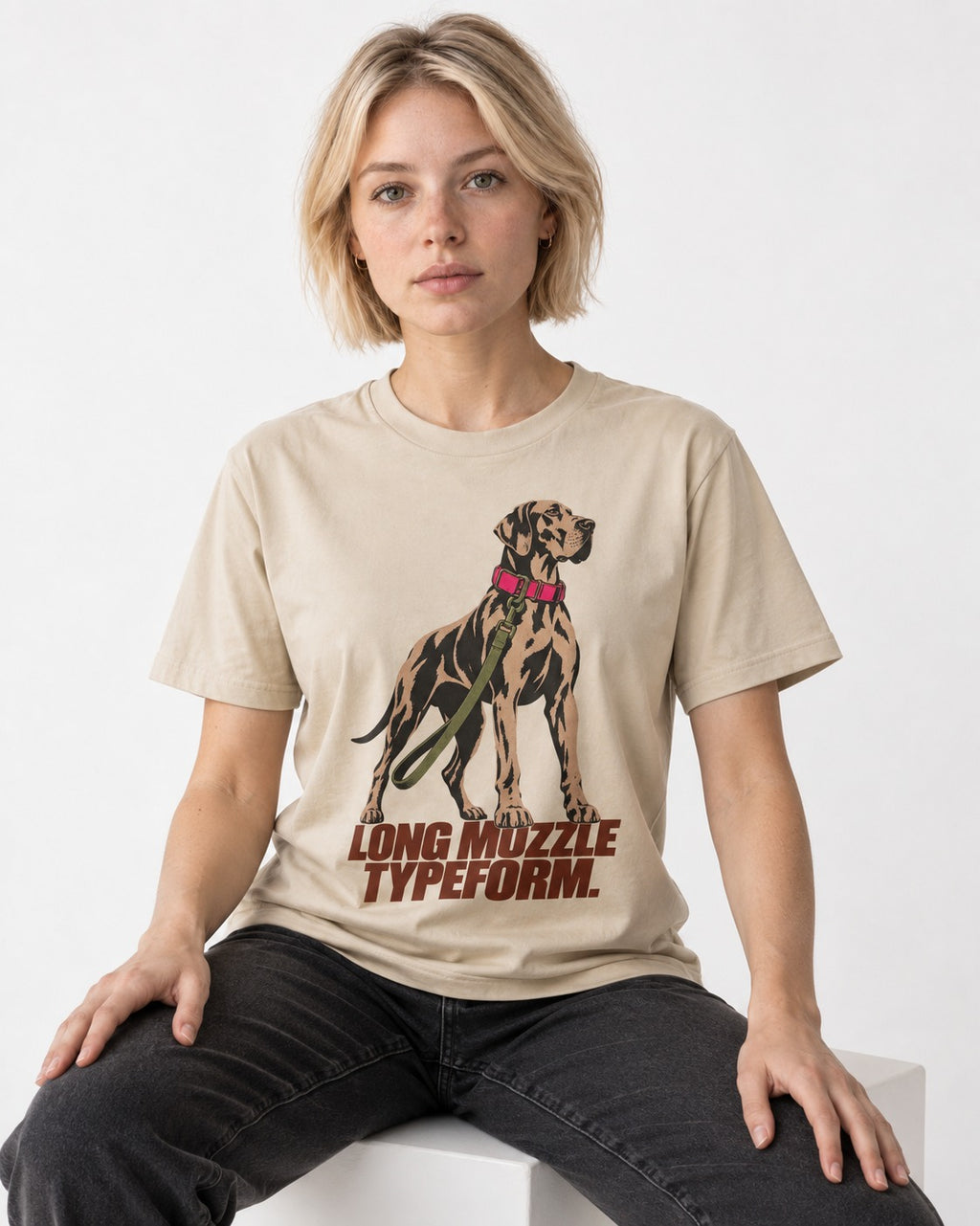 Long Muzzle Typeform Great Dane T-Shirt in Sand, worn by a seated model