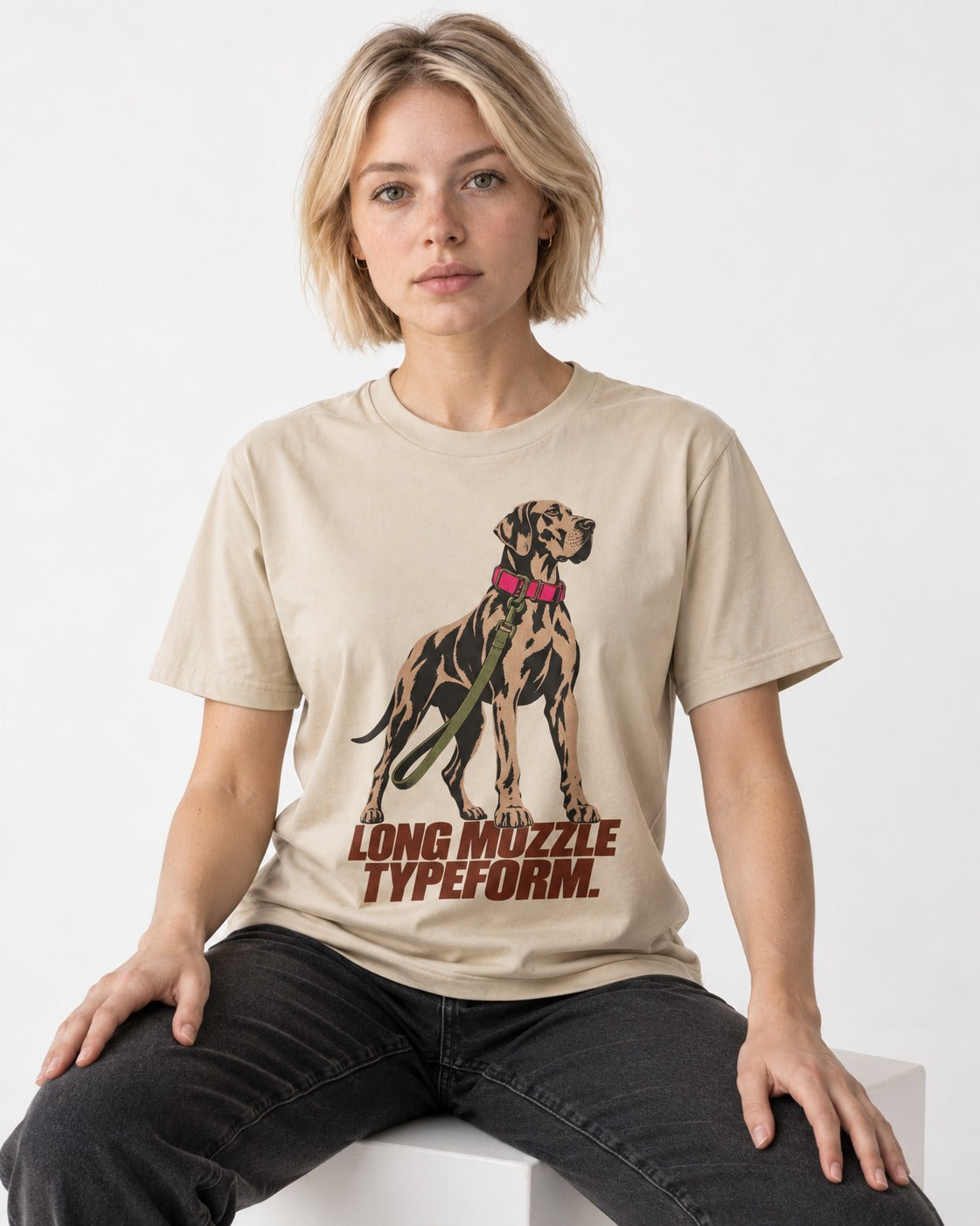 Long Muzzle Typeform Great Dane T-Shirt in Sand, worn by a seated model
