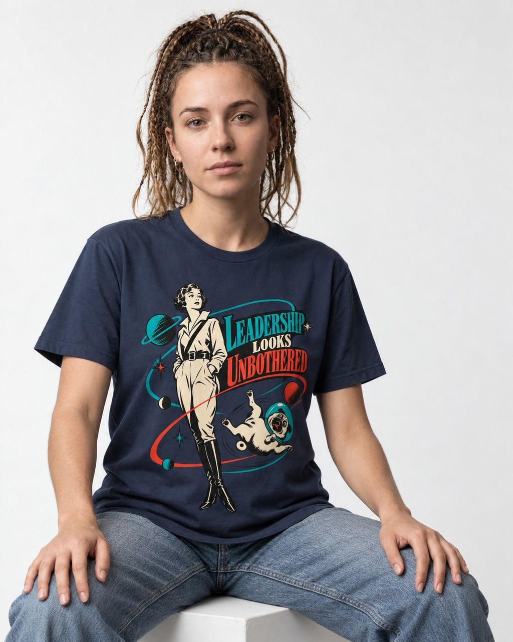 Pug Leadership Looks Unbothered Space Graphic T-Shirt in Navy, worn by a seated model