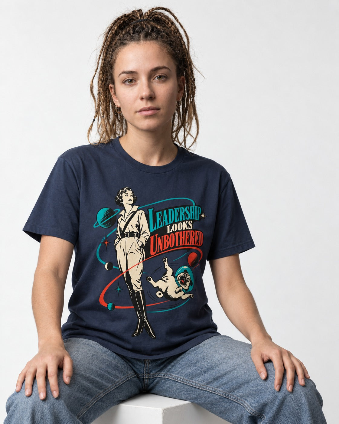 Pug Leadership Looks Unbothered Space Graphic T-Shirt in Navy, worn by a seated model