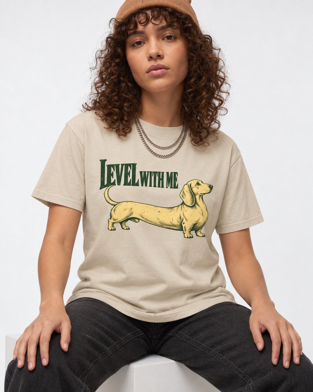 Dachshund Level with Me T-Shirt in Sand, worn by a seated model