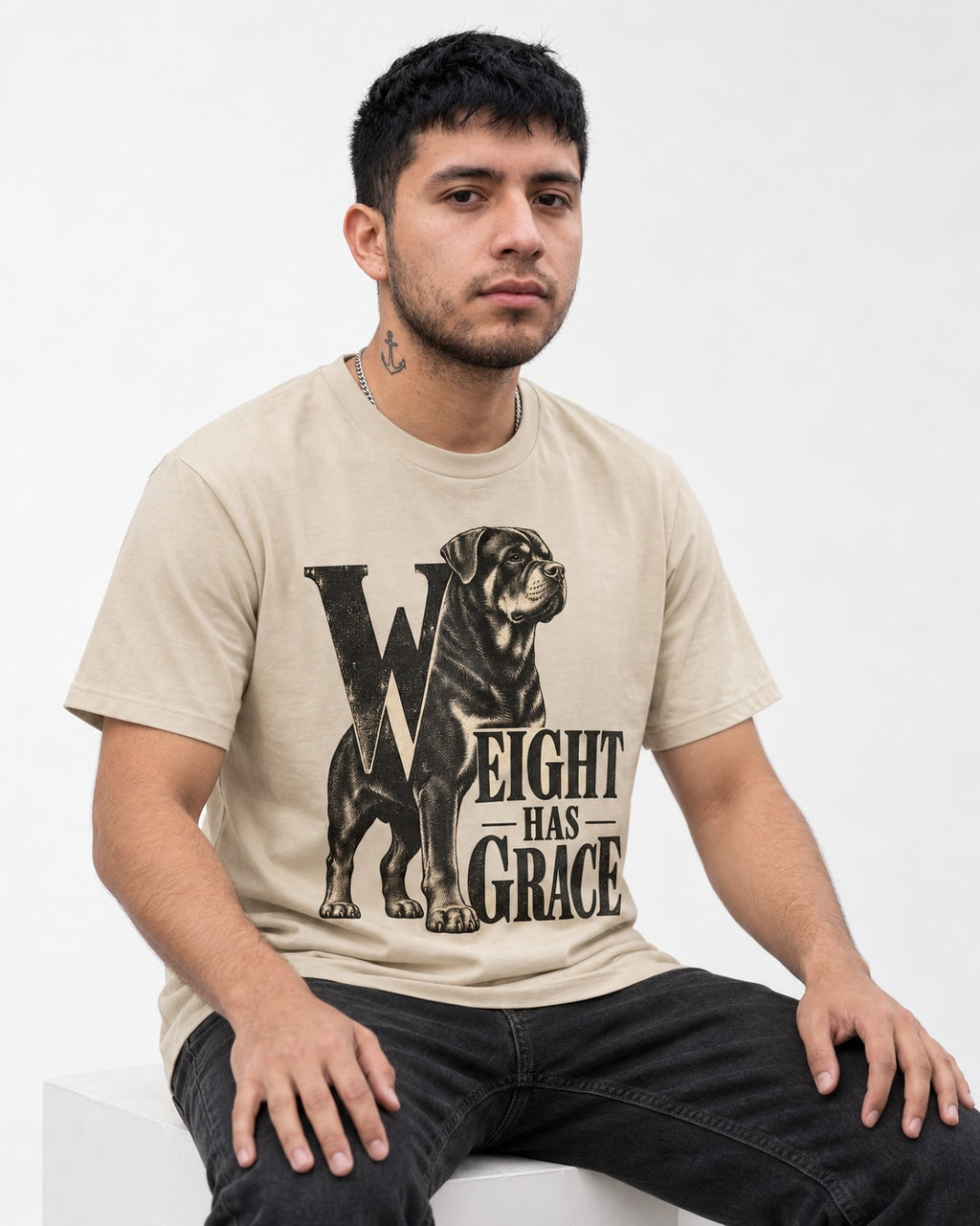 Rottweiler Weight Has Grace T-Shirt in Sand, worn by a seated model