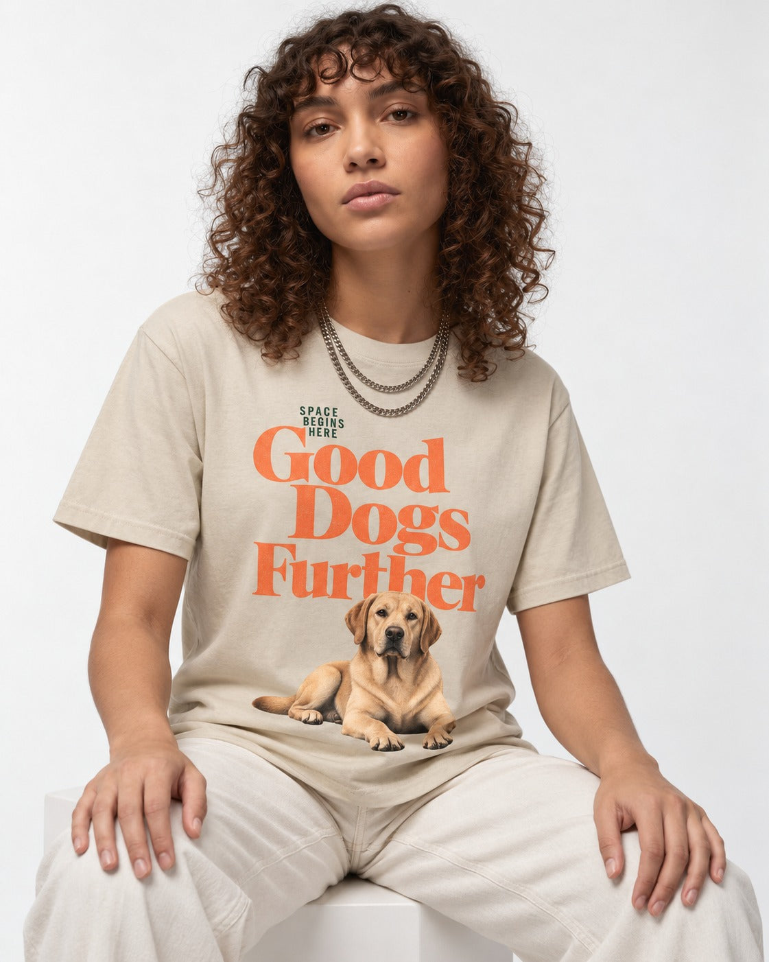 Good Labrador Retriever Goes Further T-Shirt in Sand, worn by a seated model