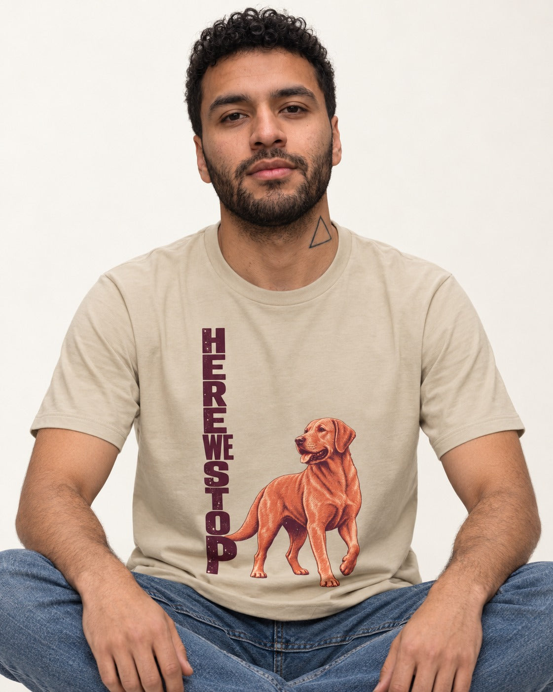 Here We Stop Labrador Retriever T-Shirt in Sand, worn by a seated model