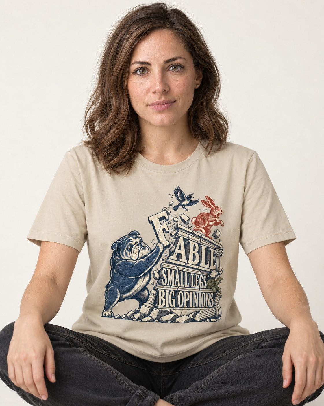 Small Legs Big Opinions English Bulldog T-Shirt in Sand, worn by a seated model