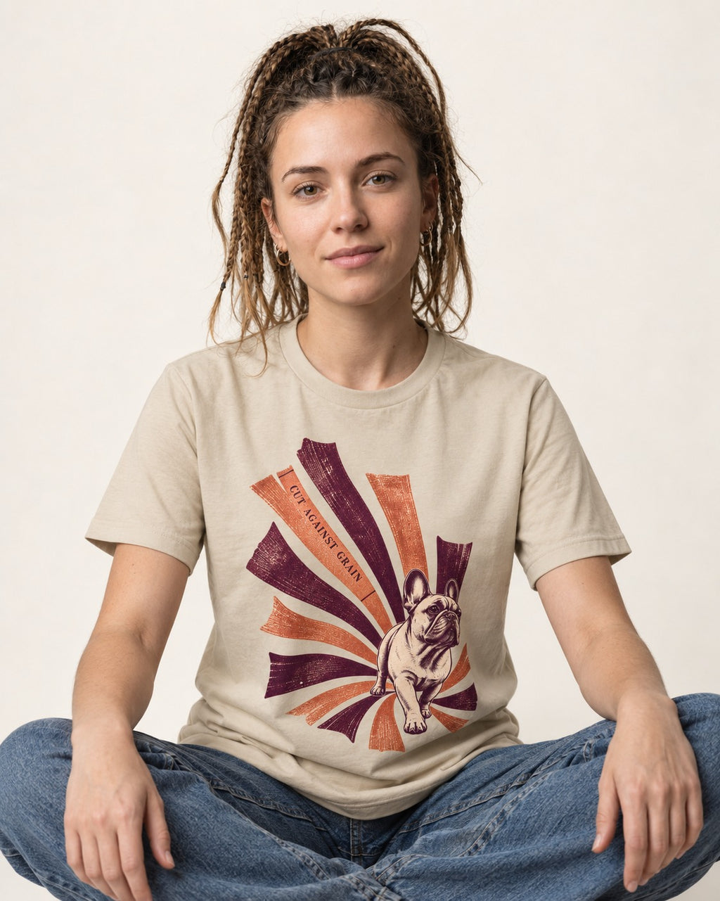 Frenchie Against the Grain T-Shirt in Sand, worn by a seated model