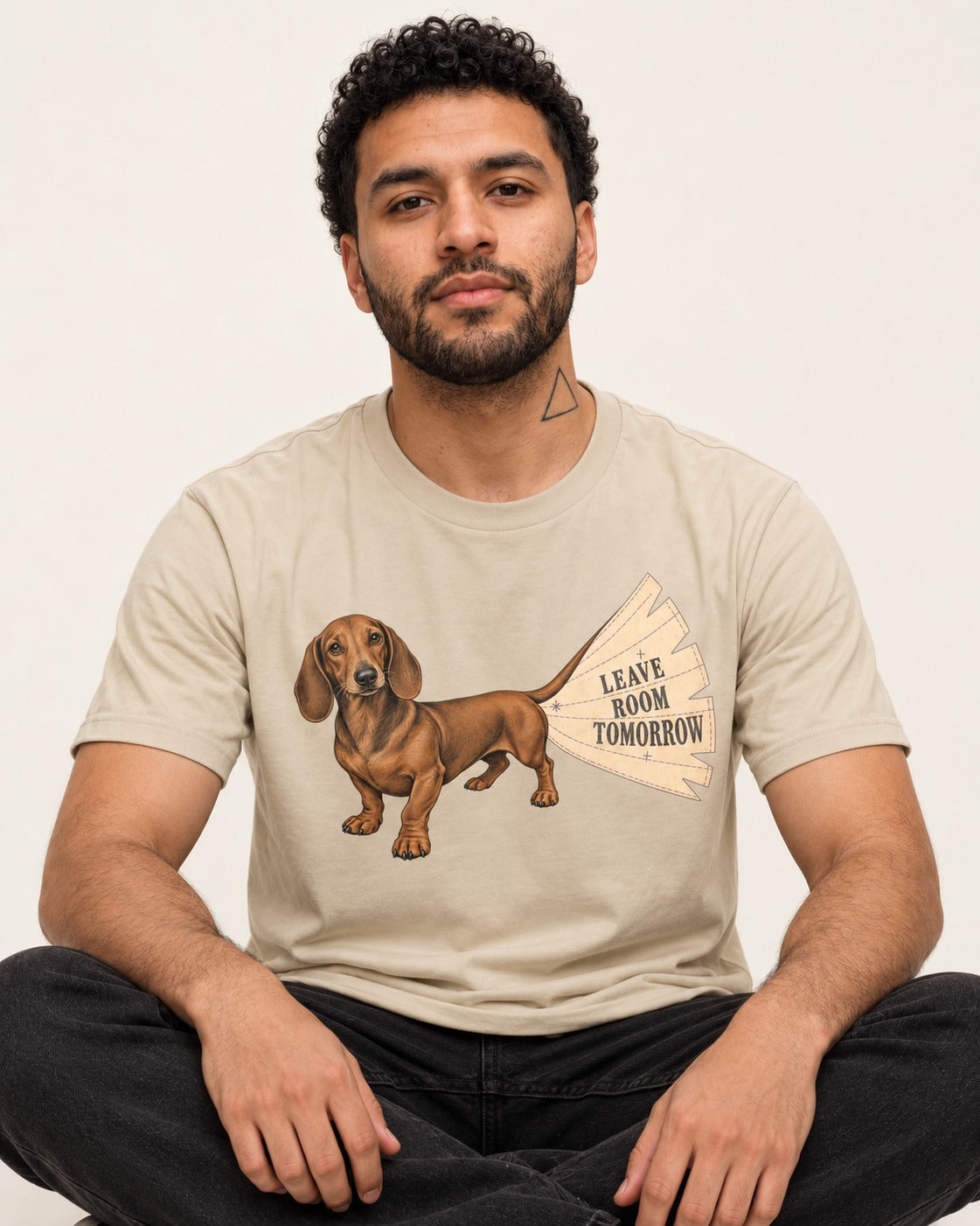 Dachshund Leave Room Tomorrow T-Shirt in Sand, worn by a seated model