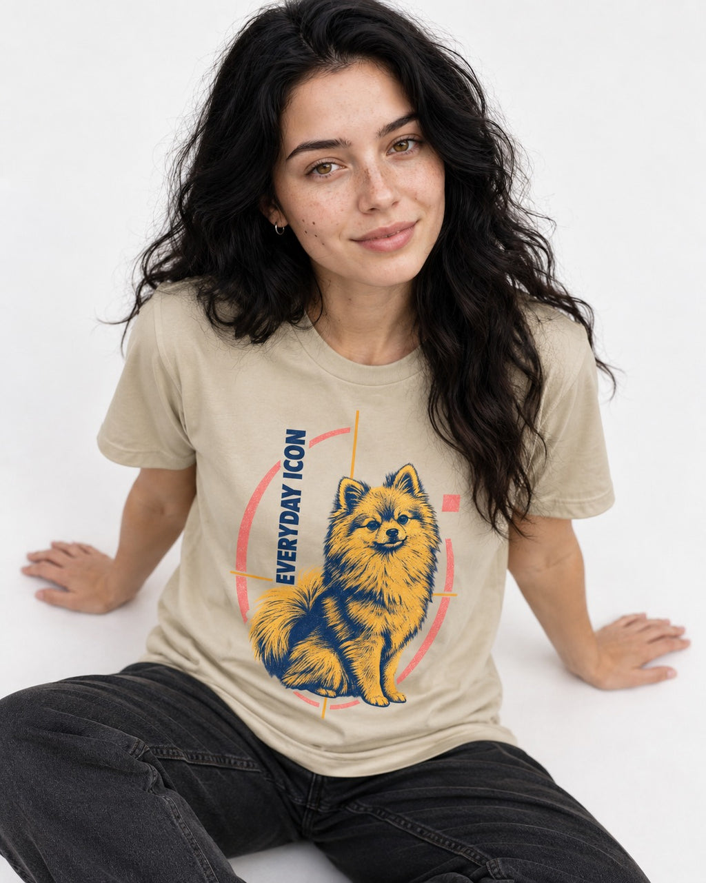 Pomeranian Everyday Icon T-Shirt in Sand, worn by a seated model