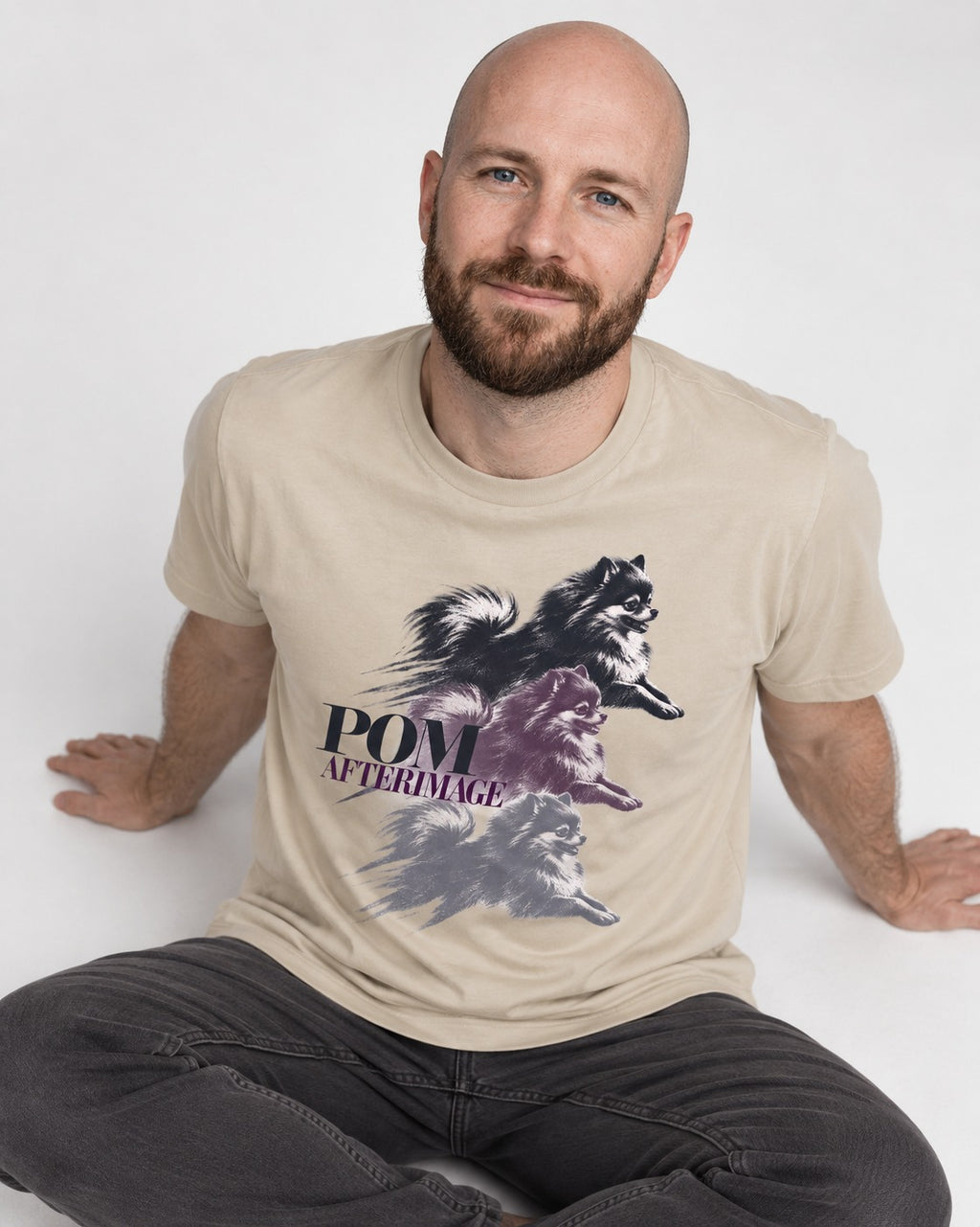 Pomeranian Afterimage T-Shirt in Sand, worn by a seated model