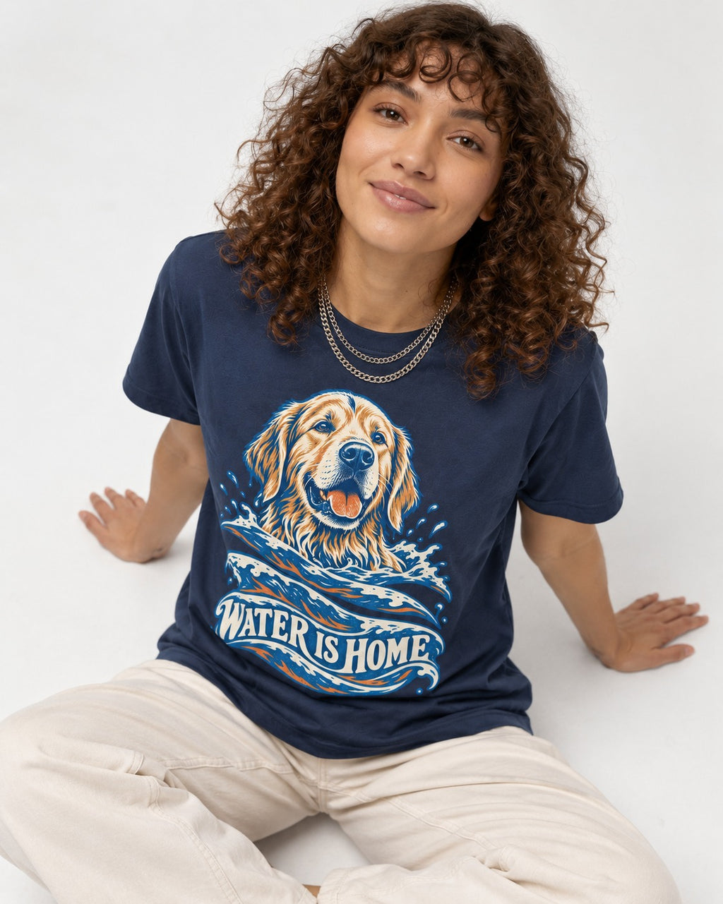 Golden Retriever Water Is Home Ocean Wave Graphic T-Shirt in Navy, worn by a seated model