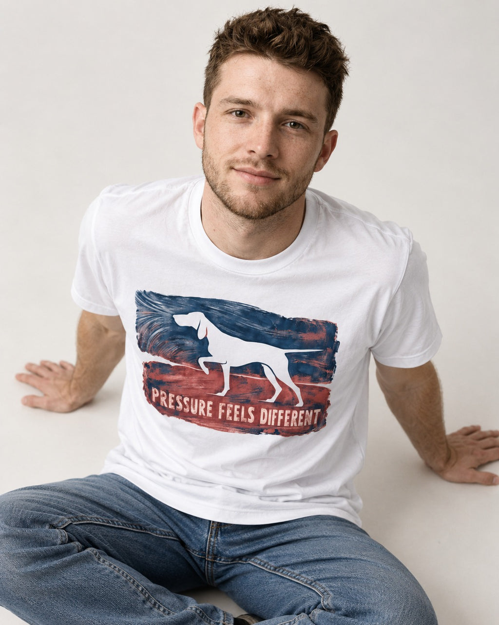 German Shorthaired Pointer Pressure Feels Different Monotype Graphic T-Shirt in White, worn by a seated model