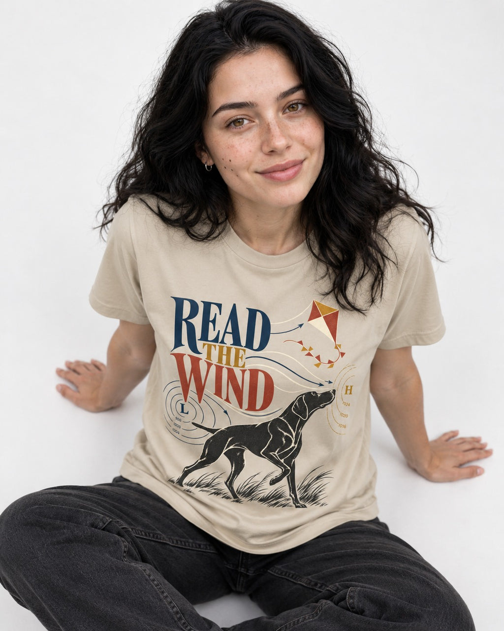 Read the Wind German Shorthaired Pointer T-Shirt in Sand, worn by a seated model