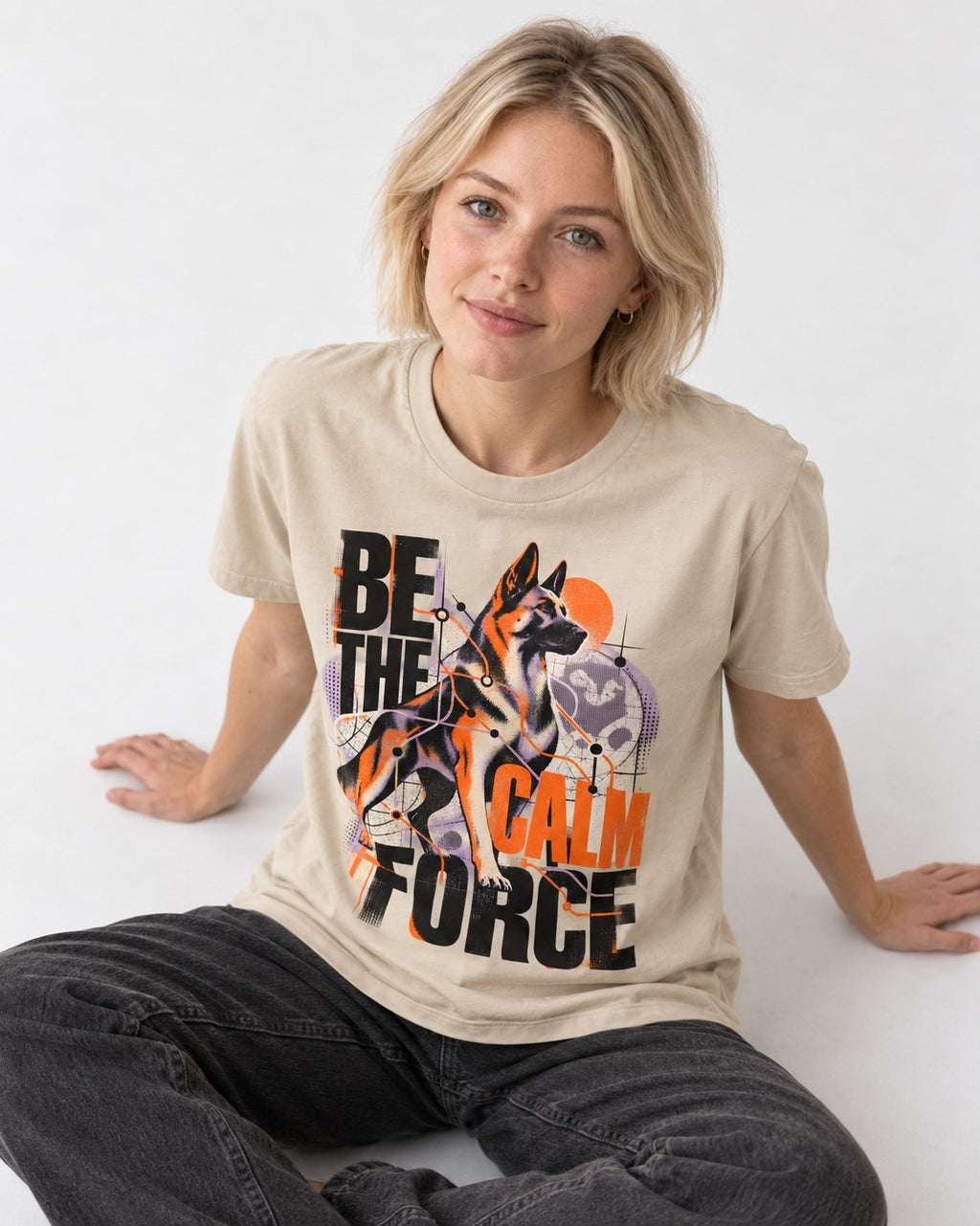 Be the Calm Force German Shepherd Dog T-Shirt in Sand, worn by a seated model