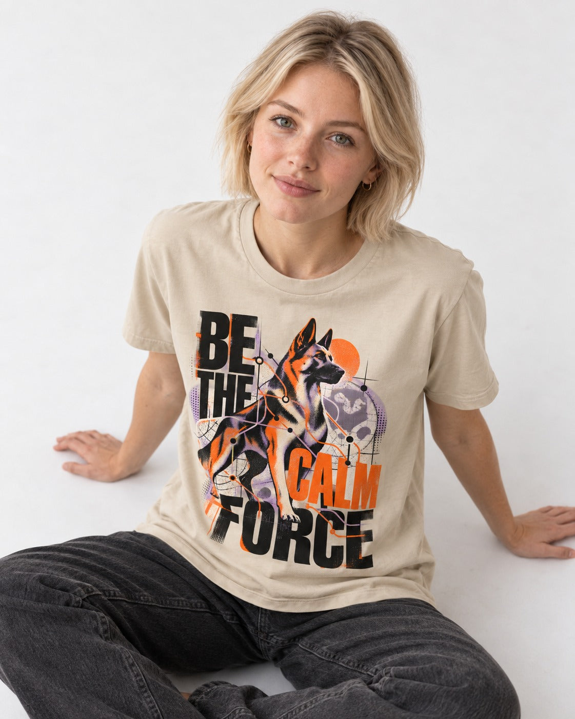 Be the Calm Force German Shepherd Dog T-Shirt in Sand, worn by a seated model