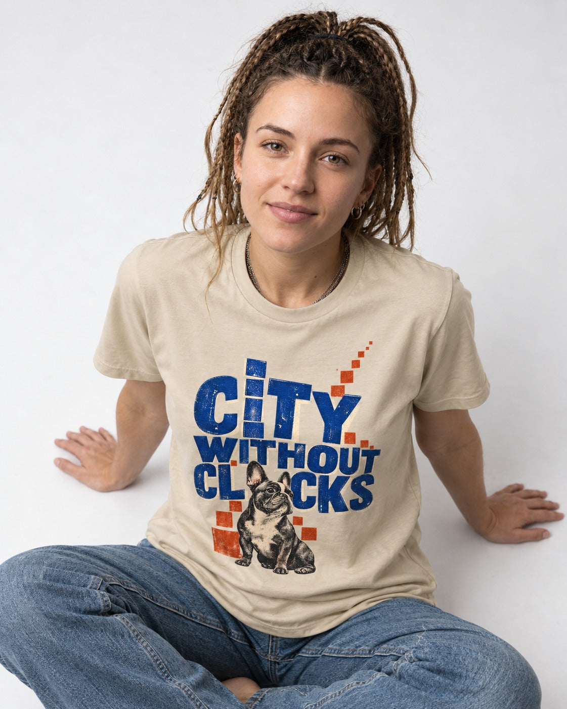 Frenchie's City Without Clocks T-Shirt in Sand, worn by a seated model
