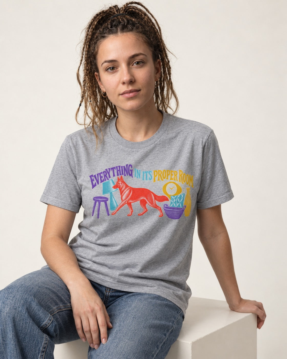 German Shepherd Dog In Its Proper Room T-Shirt in Sport Grey, worn by a seated model