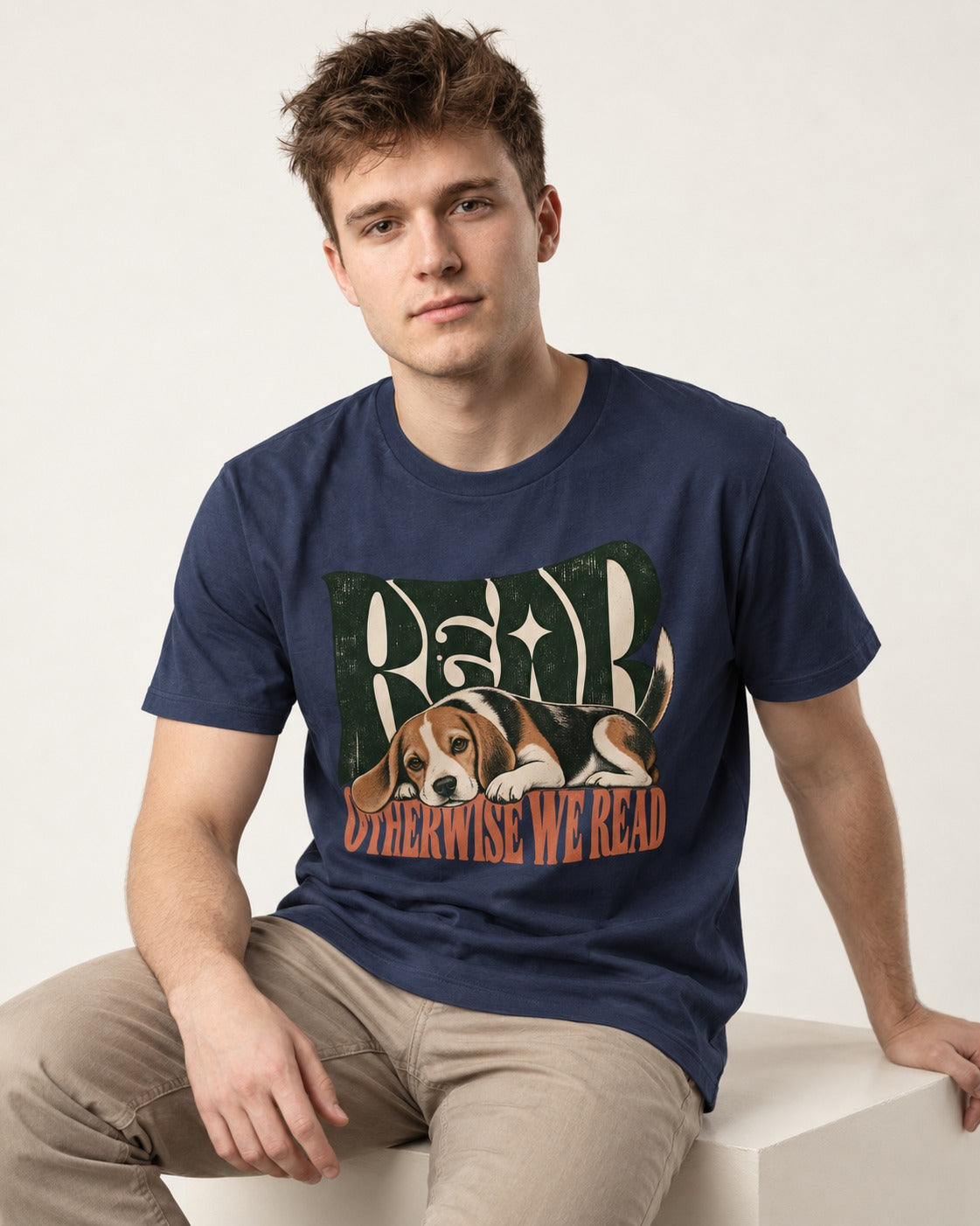Beagle Read Otherwise We Read Retro Graphic T-Shirt in Navy, worn by a seated model