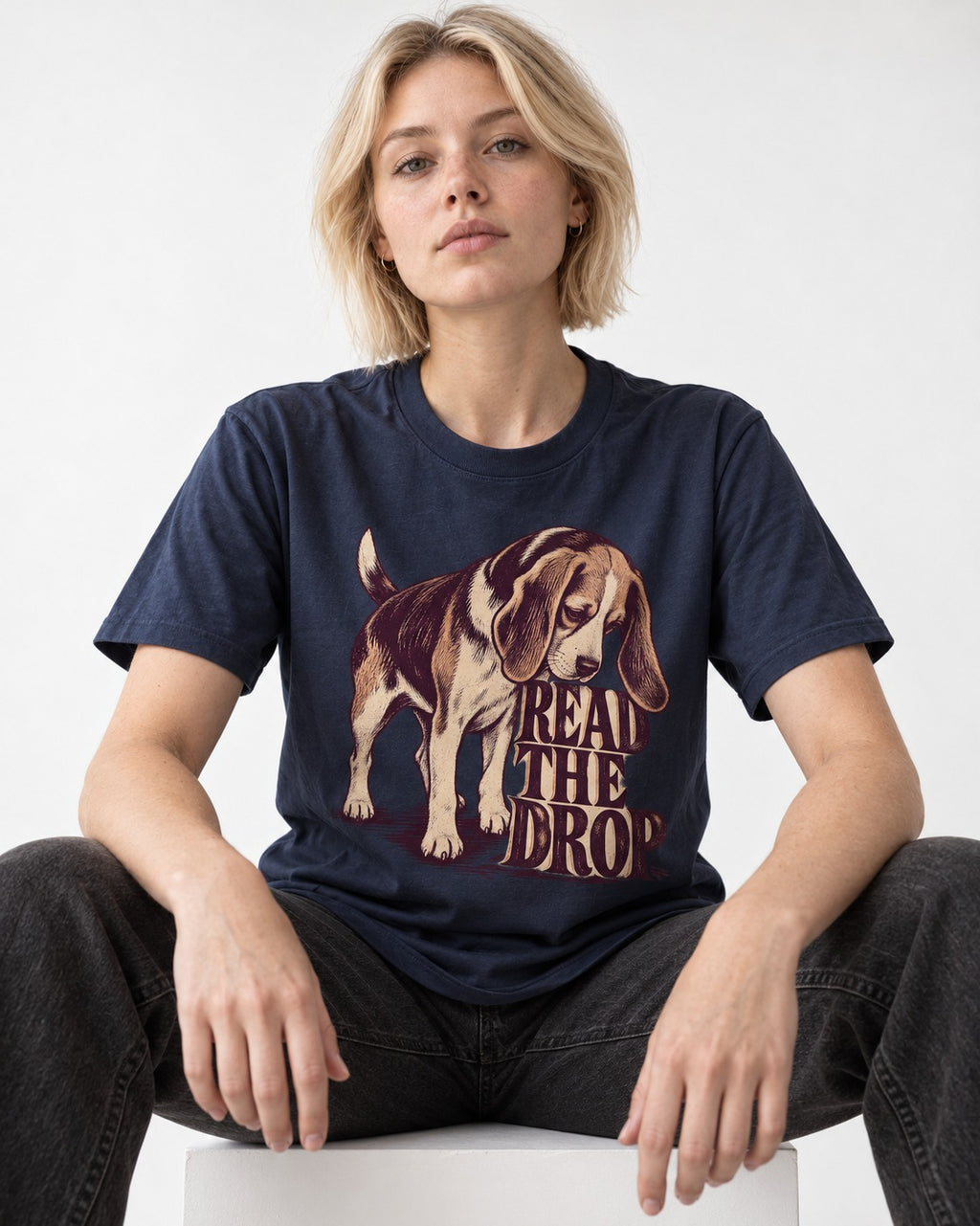 Beagle Read The Drop T-Shirt in Navy, worn by a seated model