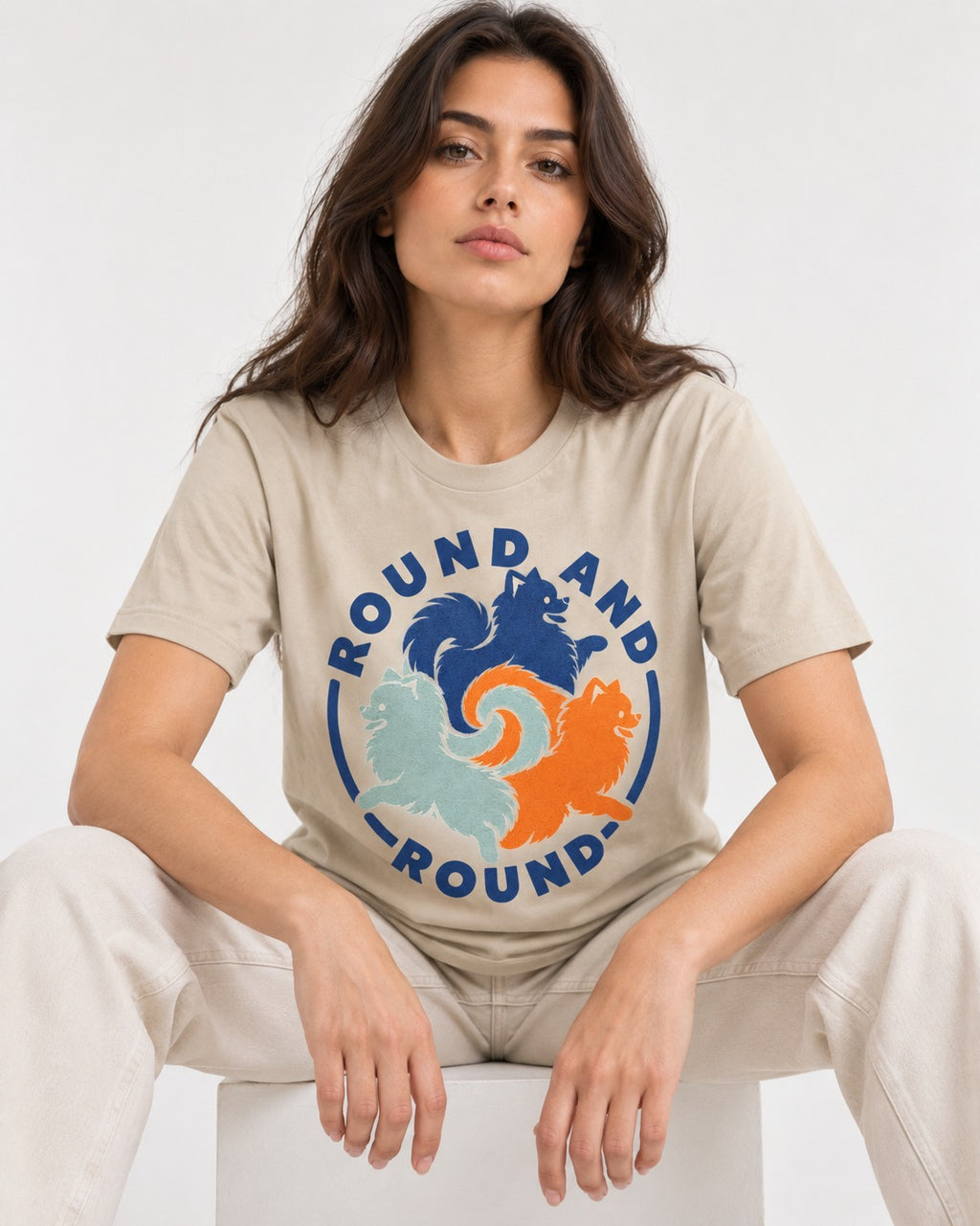 Pomeranian Round and Round T-Shirt in Sand, worn by a seated model