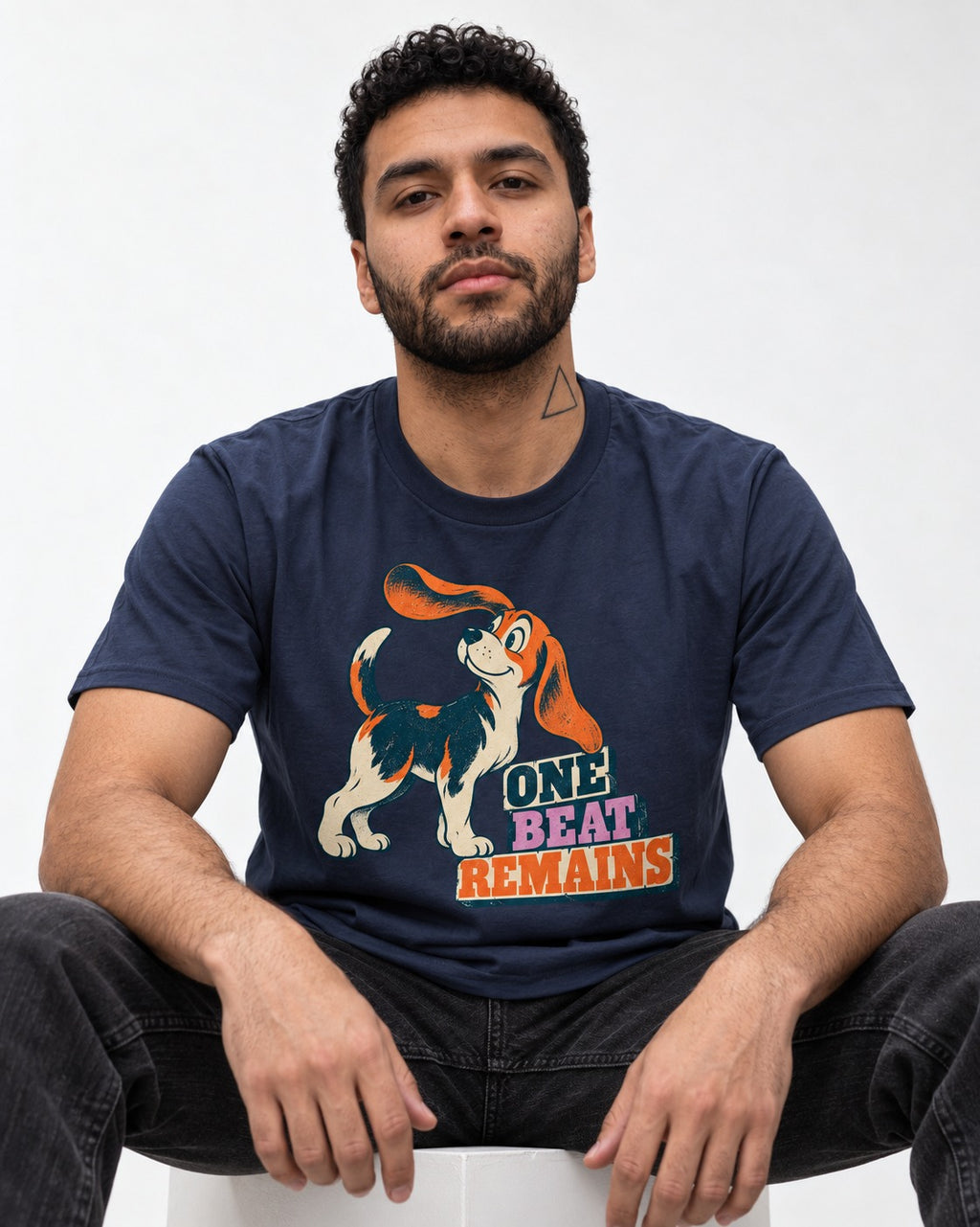 Retro Beagle One Beat Remains T-Shirt in Navy, worn by a seated model