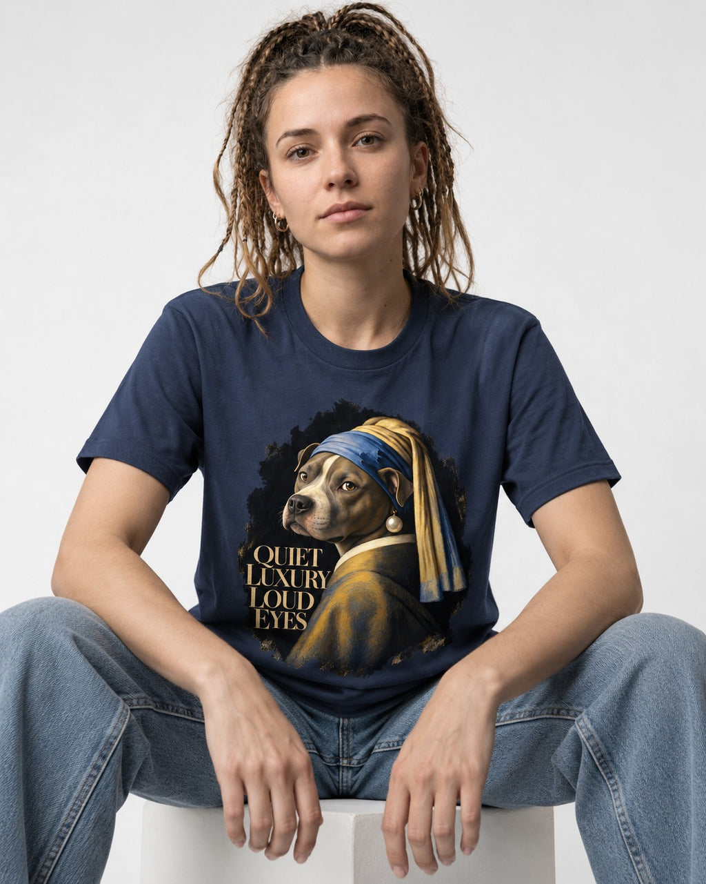 Pitbull Quiet Luxury Loud Eyes Pearl Earring Portrait Graphic T-Shirt in Navy, worn by a seated model