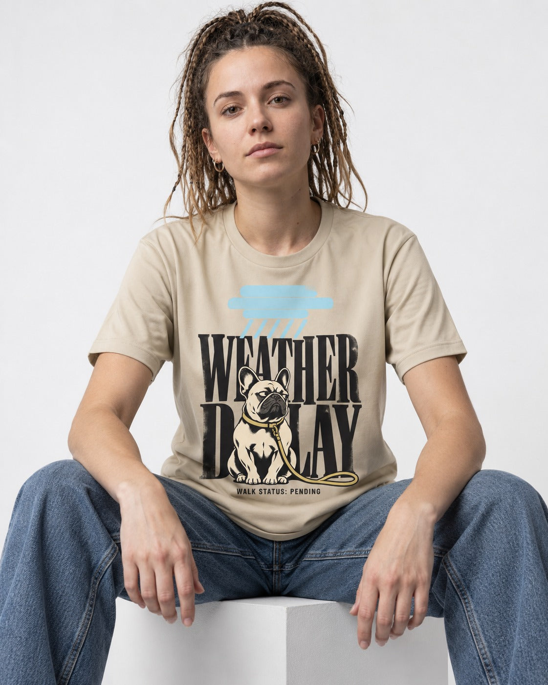 Frenchie Weather Delay T-Shirt in Sand, worn by a seated model