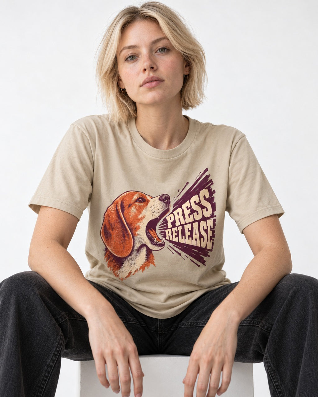 Beagle Press Release T-Shirt in Sand, worn by a seated model