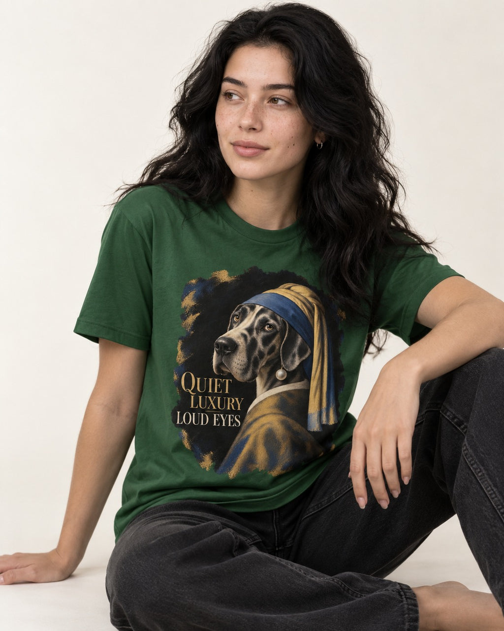 Great Dane Quiet Luxury Loud Eyes Pearl Portrait Graphic T-Shirt in Forest Green, worn by a seated model
