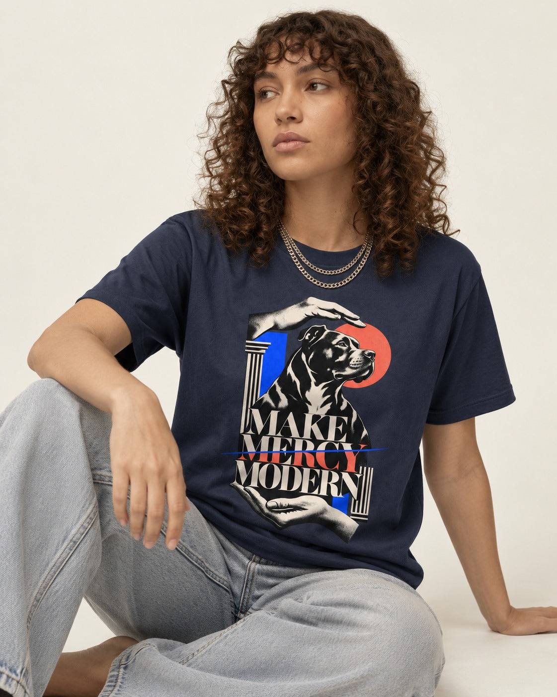 Pitbull Make Mercy Modern Protective Hands Graphic T-Shirt in Navy, worn by a seated model
