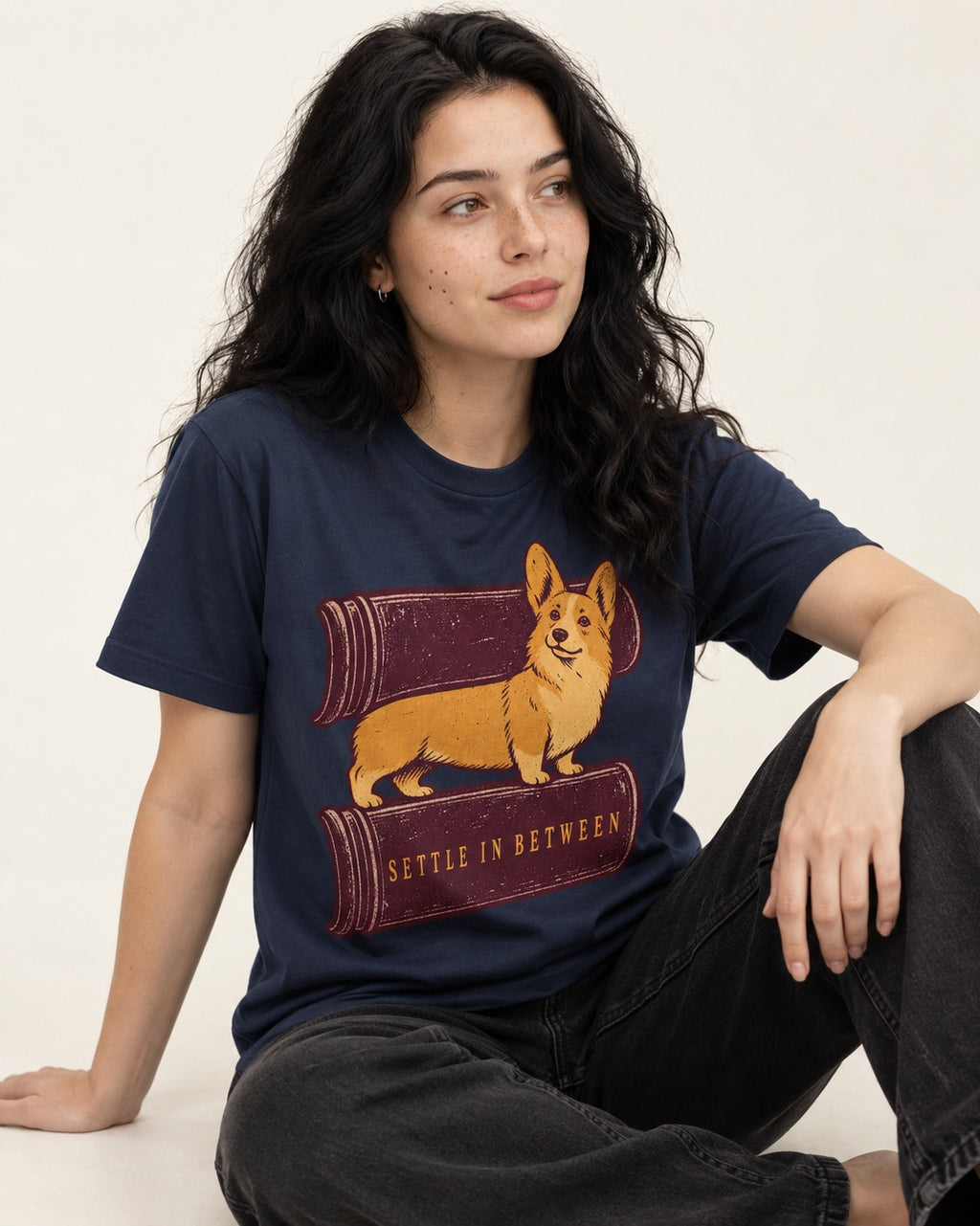 Corgi Settle in Between T-Shirt in Navy, worn by a seated model