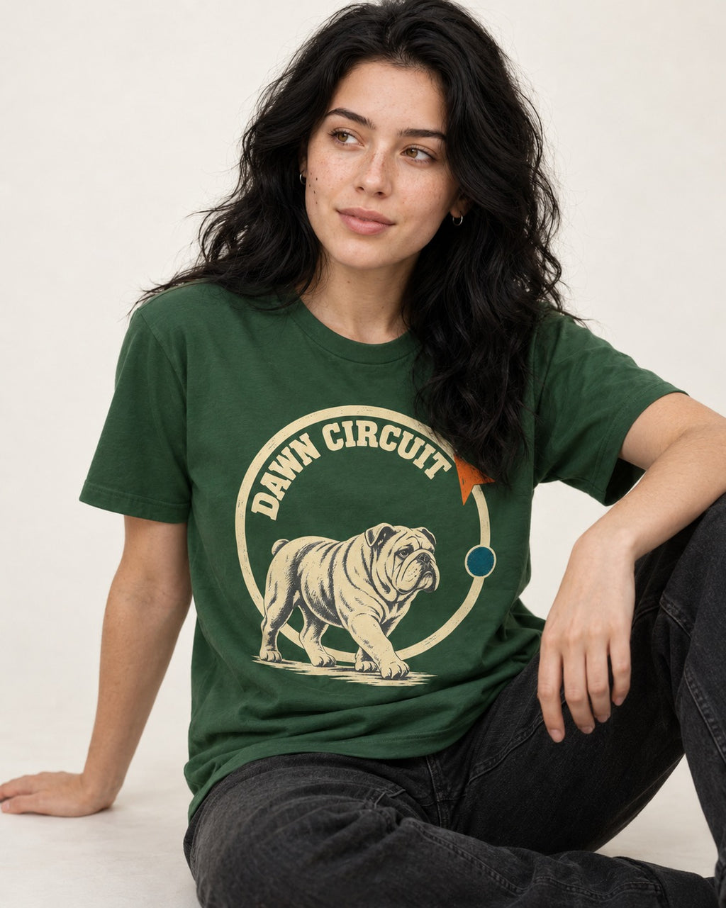 English Bulldog Dawn Circuit Emblem T-Shirt in Forest Green, worn by a seated model