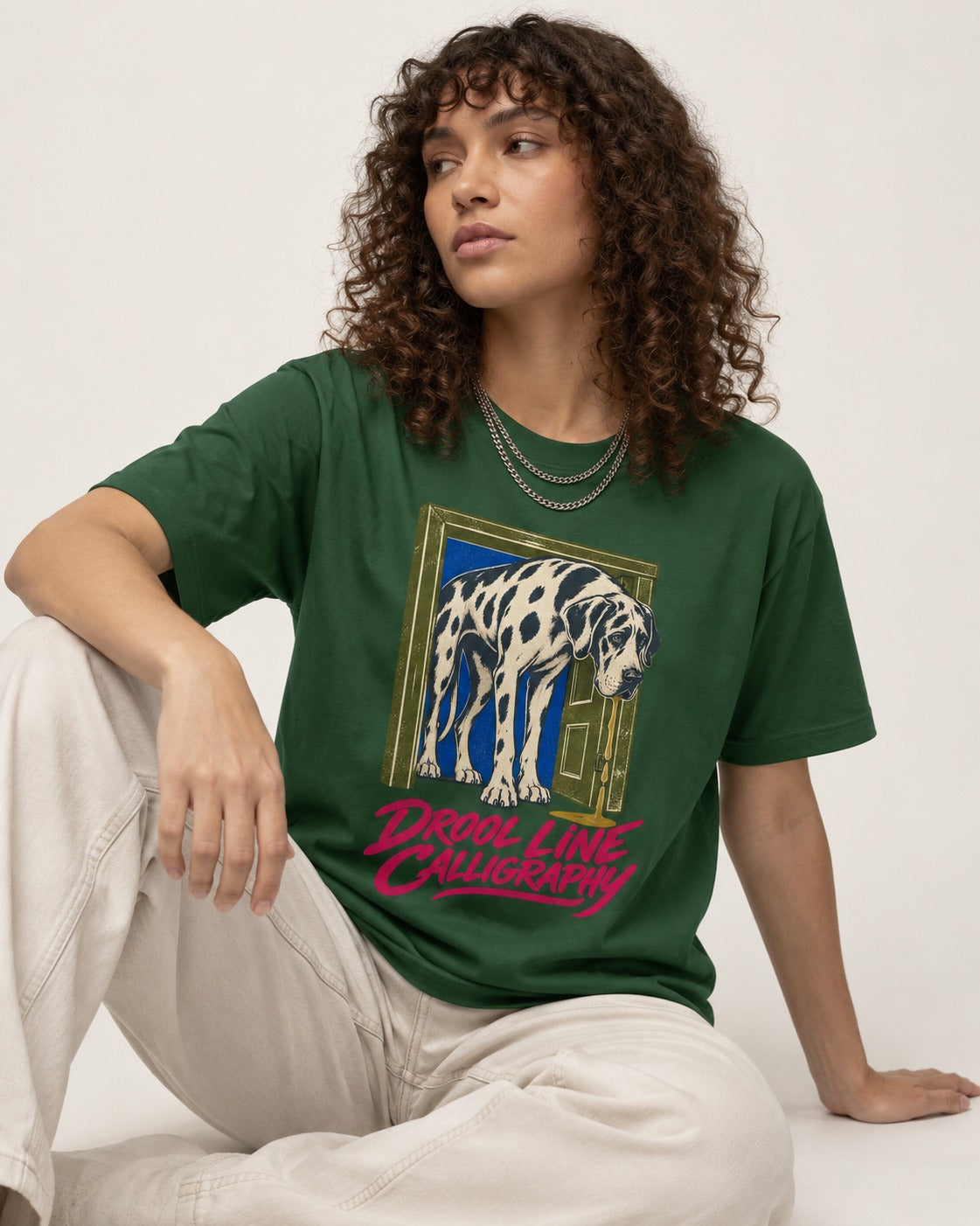 Great Dane Drool Line Calligraphy Doorway Graphic T-Shirt in Forest Green, worn by a seated model