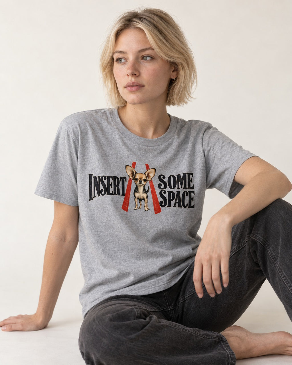 Insert Some Chihuahua Space T-Shirt in Sport Grey, worn by a seated model