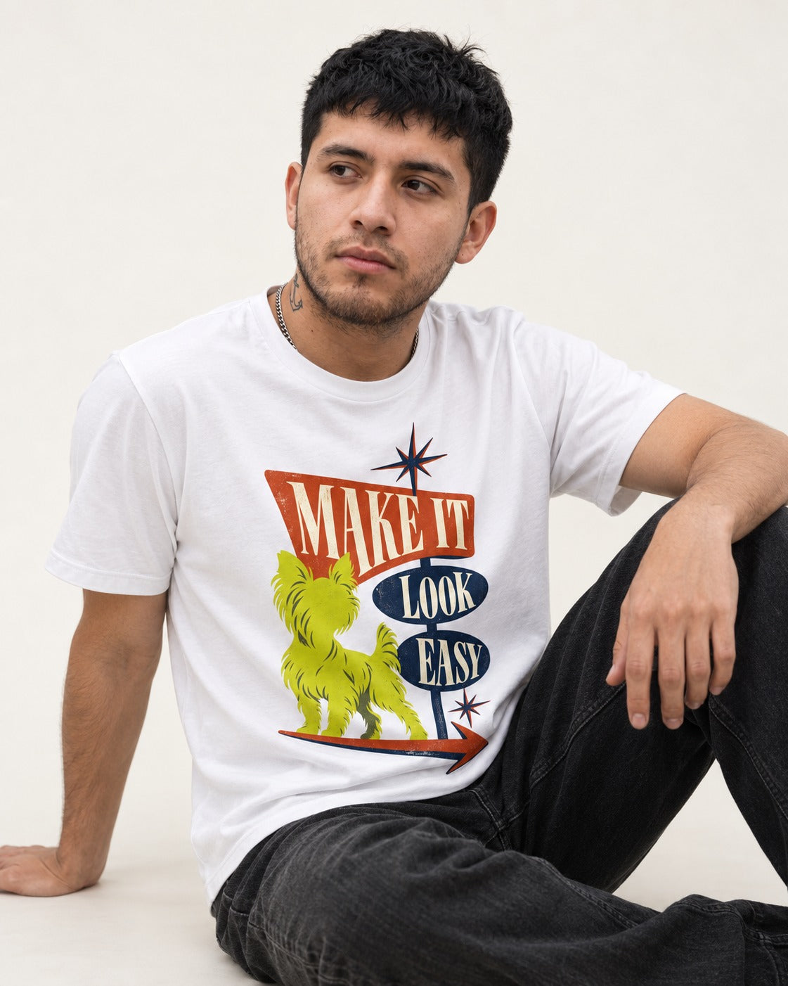 Yorkshire Terrier Make It Look Easy Retro Sign Graphic T-Shirt in White, worn by a seated model