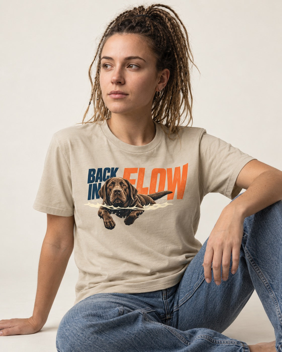Labrador Retriever Back in Flow T-Shirt in Sand, worn by a seated model